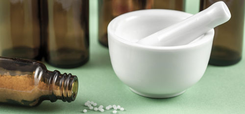 Startseite Beruf Heilpraktiker Ein weißer Mörser, links daneben ein liegendes, braunes Fläschchen gefüllt mit Mitteln der Heilpraktik