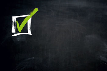 Weißer Kasten mit grünem Haken auf dunklem Untergrund